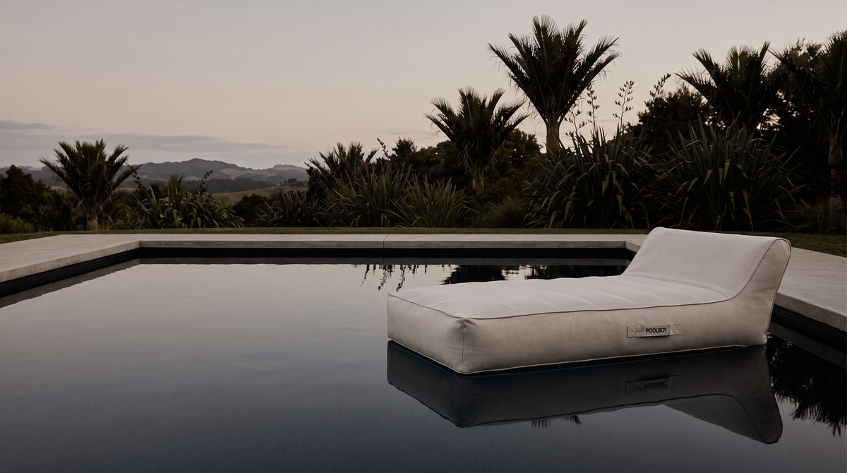 Poolboy Floata-Long floating on a still New Zealand pool at dusk with native planting
