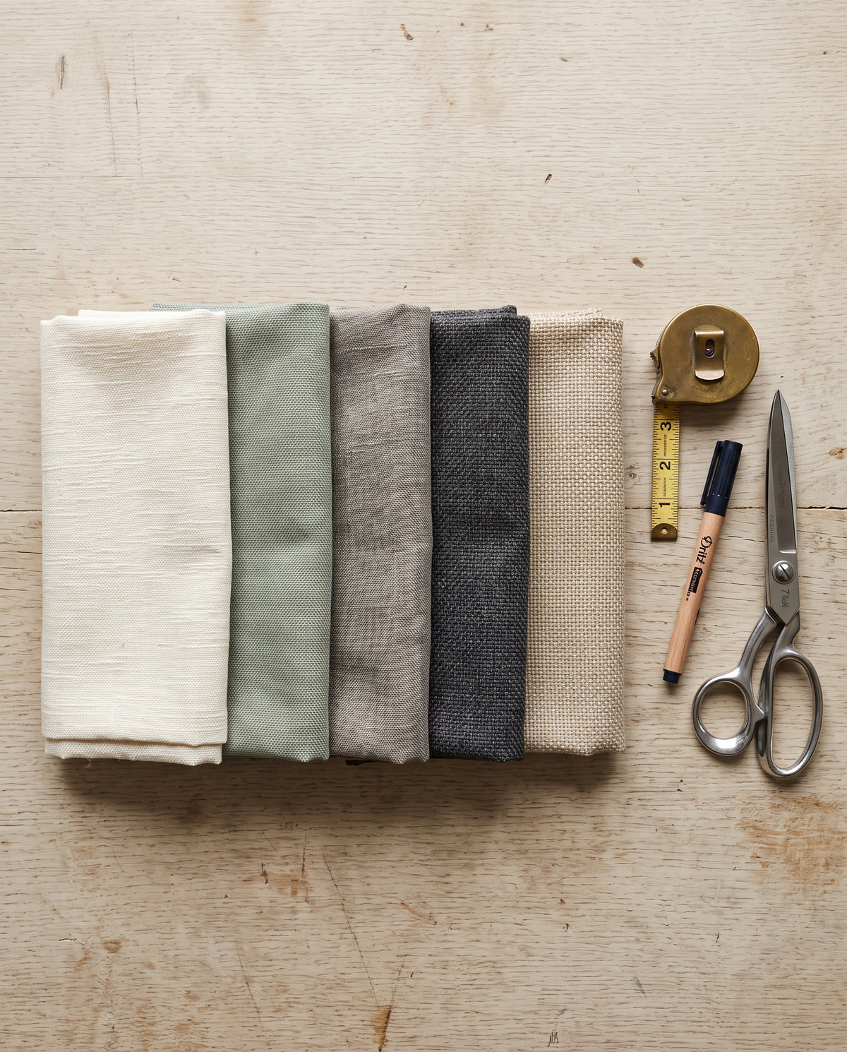 Folded Olefin fabric swatches in five colourways on a workbench