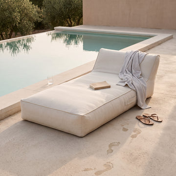 Poolboy Floata-Long in Cloud white by the pool, a towel left over it.