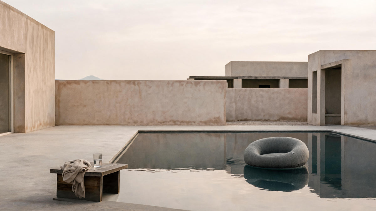 Poolboy Floata-Round in Mist grey floating on a still courtyard pool.