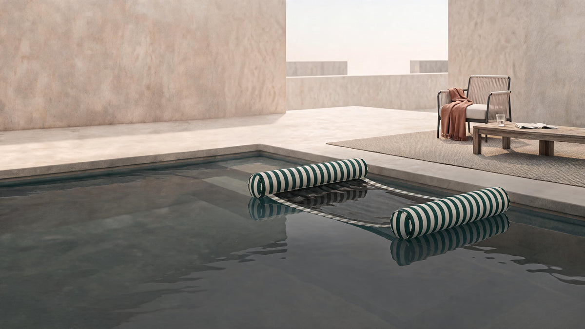 Poolboy Sinka-Bit in Green and White stripe sitting low in a still courtyard pool.
